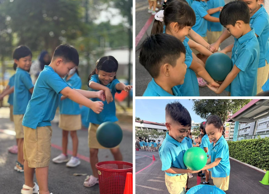 Children in blue uniforms play a ball game outdoors, passing a ball and dropping it into a basket.